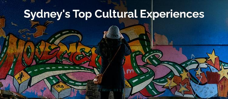 a girl in a hat facing toward the Opera House or walking along The Rocks or a suburb similar to Newtown. Text on image: Sydney's Top Cultural Experiences  